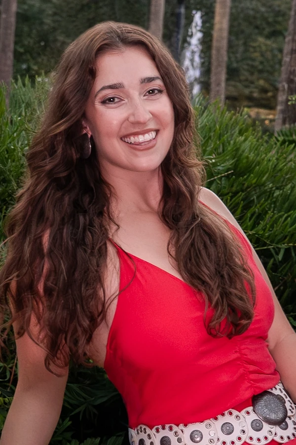 Jaime Arin smiling in a red dress
