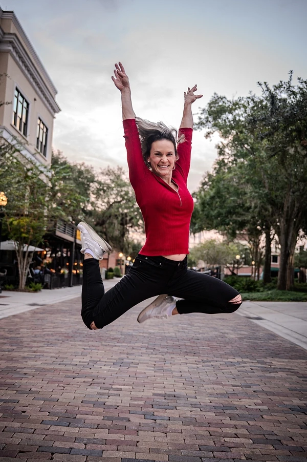 Jessica Lorion leaping into the air in a red top
